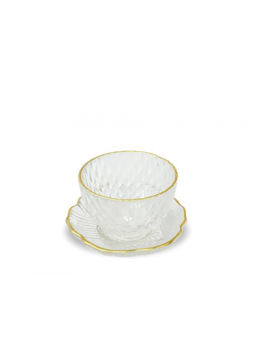 Transparent glass cup with golden edges and saucer